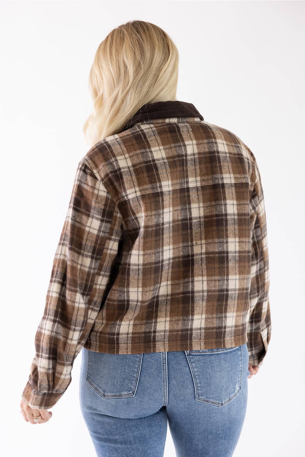 Model wearing the Brown and Cream Plaid Barn Jacket with a dark brown corduroy collar, viewed from the back to showcase the plaid pattern and fit, paired with blue jeans.