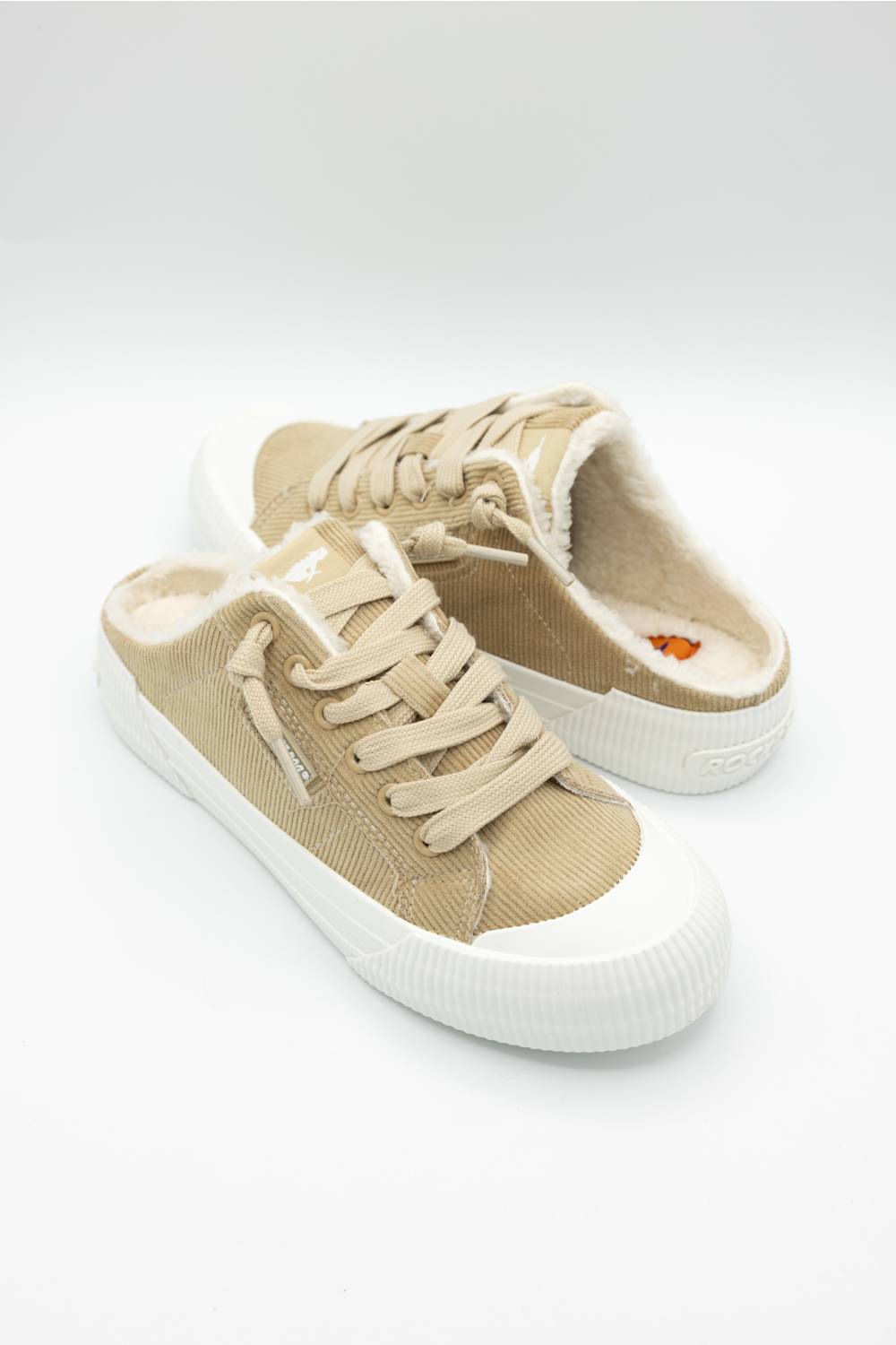 A single low-top slip-on sneaker in beige canvas with a white rubber sole, shown from the side on a light gray background.