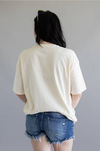 Person wearing a white t-shirt and denim shorts against a plain background