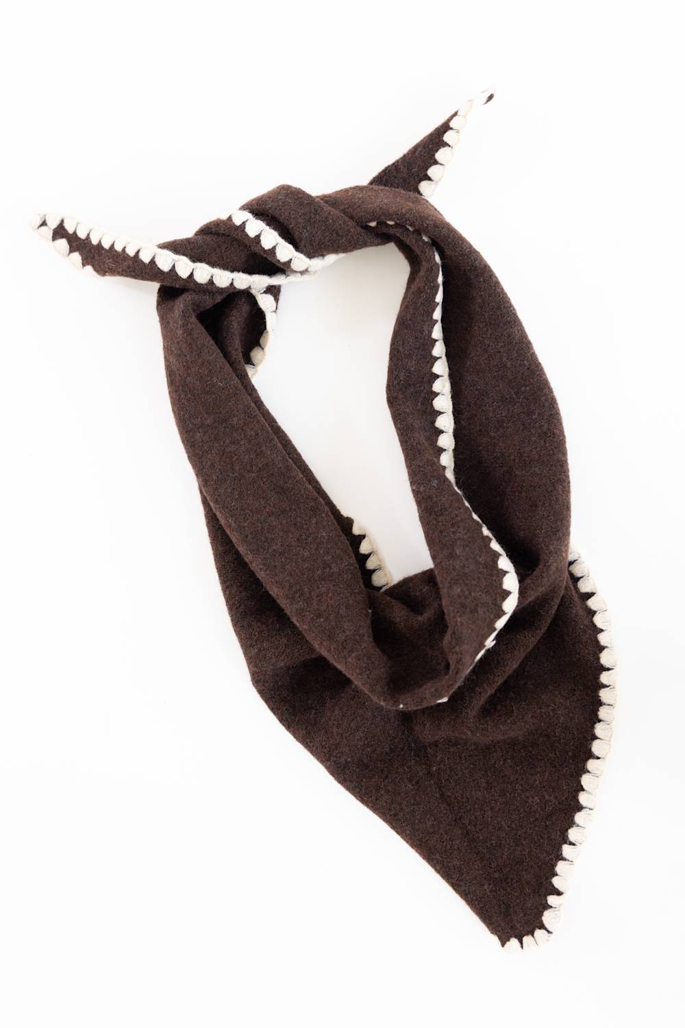 A dark brown wool scarf with white serrated edges, styled on a white mannequin torso against a white background.
