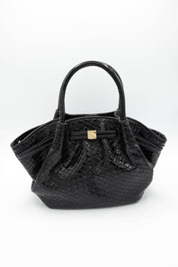 Black crocodile-embossed leather handbag with double top handles and a small gold-tone front accent, photographed on a clean white background.