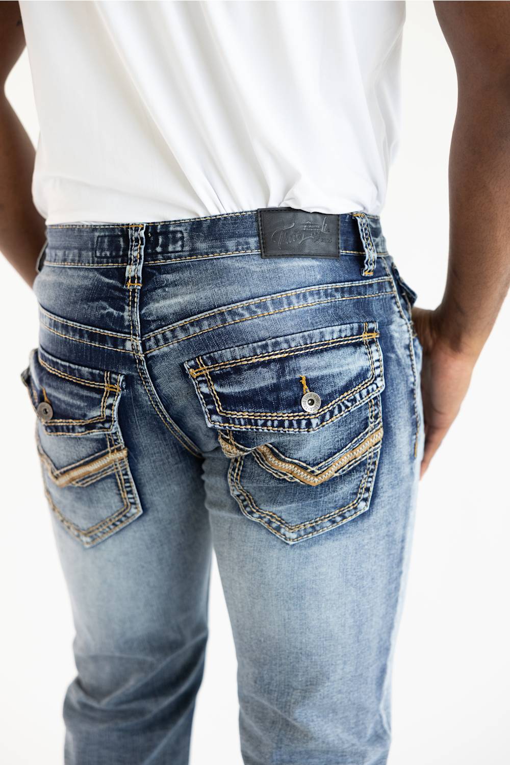 Rear view of a person wearing light blue denim jeans with a white shirt, showing the back pockets and waistband details against a plain white background.