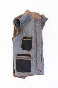 FX Fusion Upland Quilted Field Vest in charcoal shown laid flat on a white background, featuring diamond quilting, brown faux-suede contrast trim, a snap-front closure, and utility chest and hand pockets.