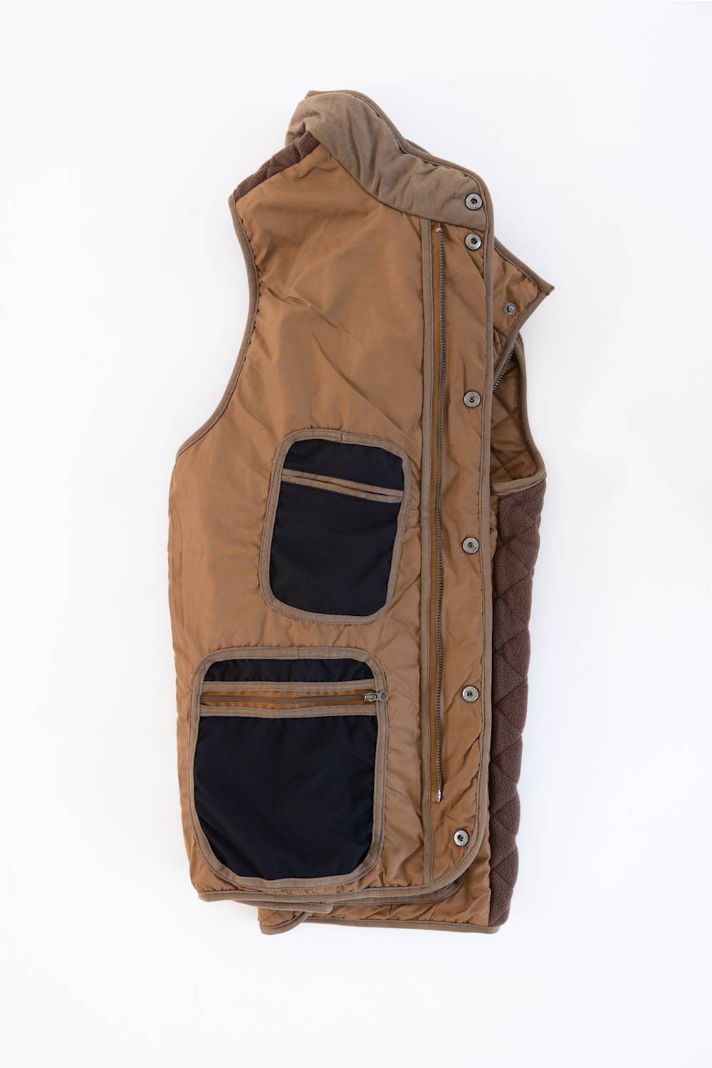 Side view of the brown F/X Fusion Upland Quilted Field Vest showing contrasting dark side panels and patch pockets.