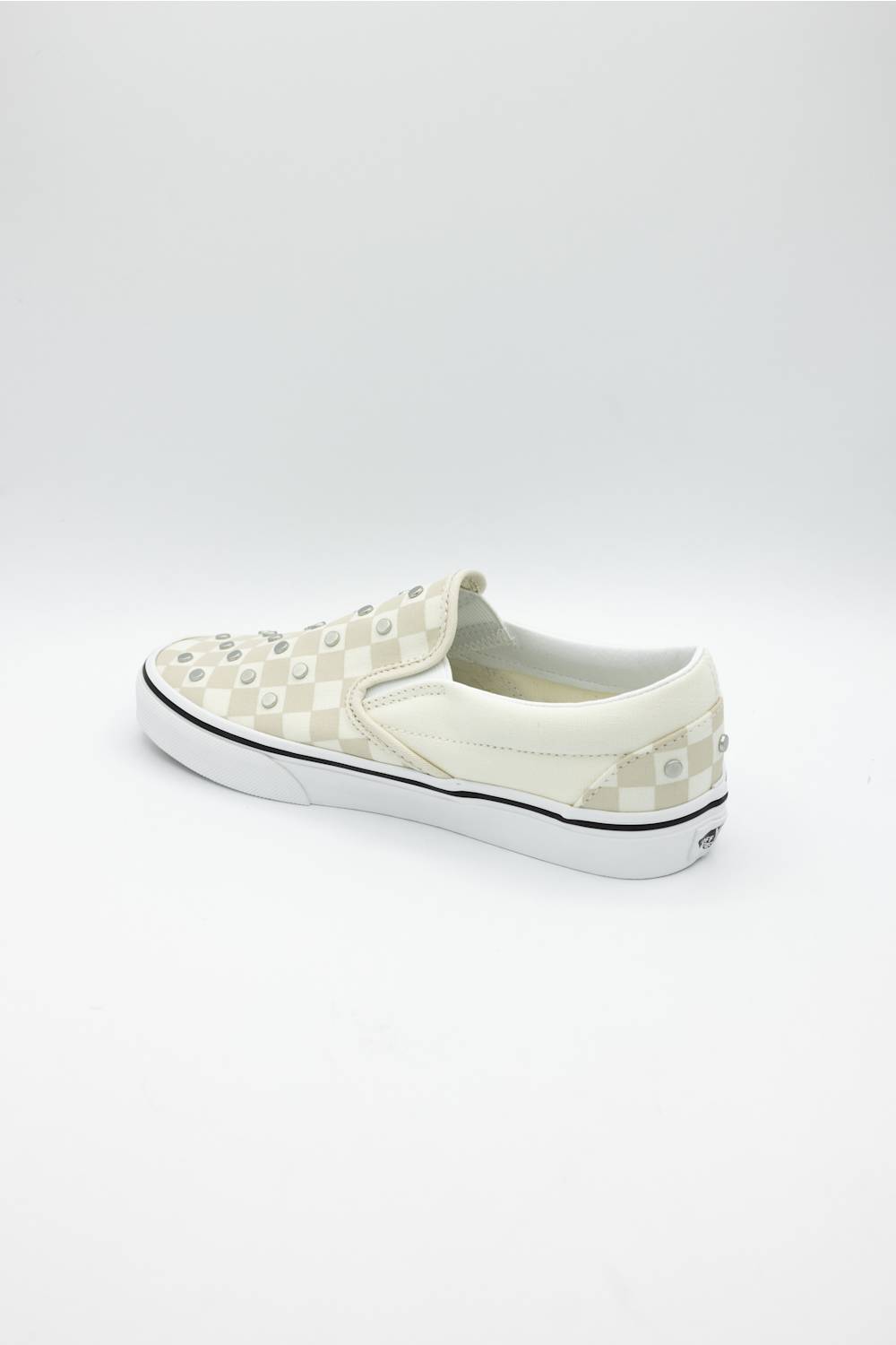 A single slip-on platform sneaker by Vans, featuring a cream and white checkerboard pattern with raised studs on the toe box, a thick white platform sole, and a thin black stripe along the midsole.