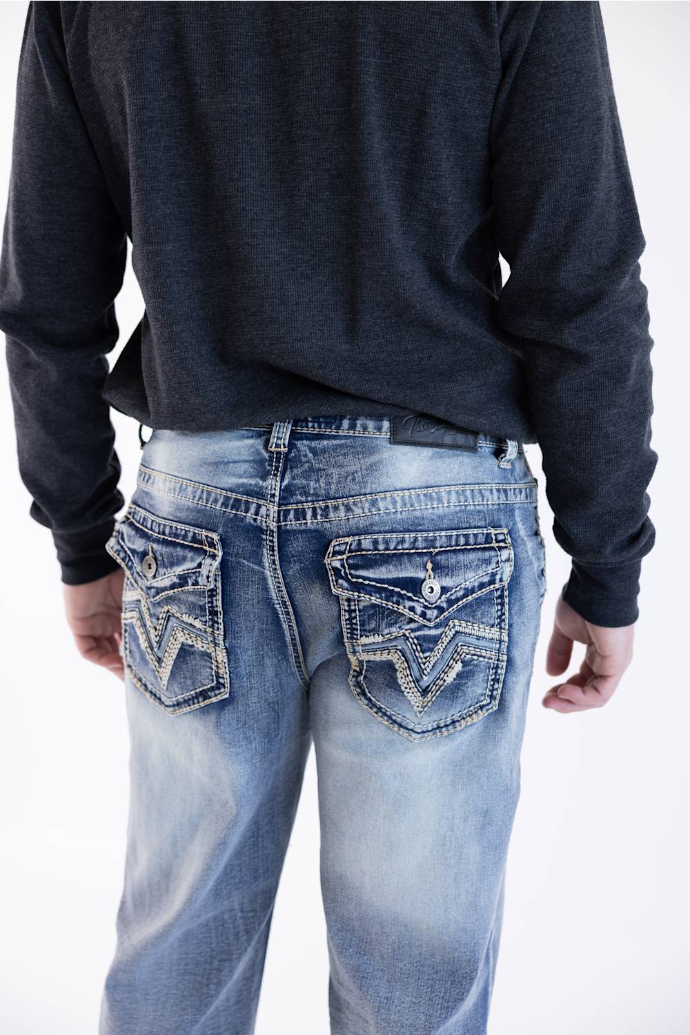 Rear view of a person wearing light wash True Luck Weller loose straight-leg jeans, showcasing the intricate embroidery on the back pockets, against a white background.
