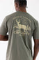 A man viewed from behind wearing a sage green Carhartt t-shirt with a large beige graphic on the back featuring a deer, trees, and the Carhartt logo.