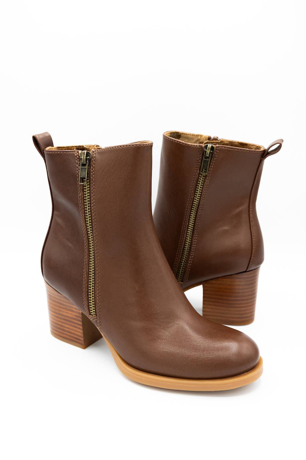 A pair of brown leather ankle boots with side zippers, block heels, and pull tabs, shown on a plain white background.