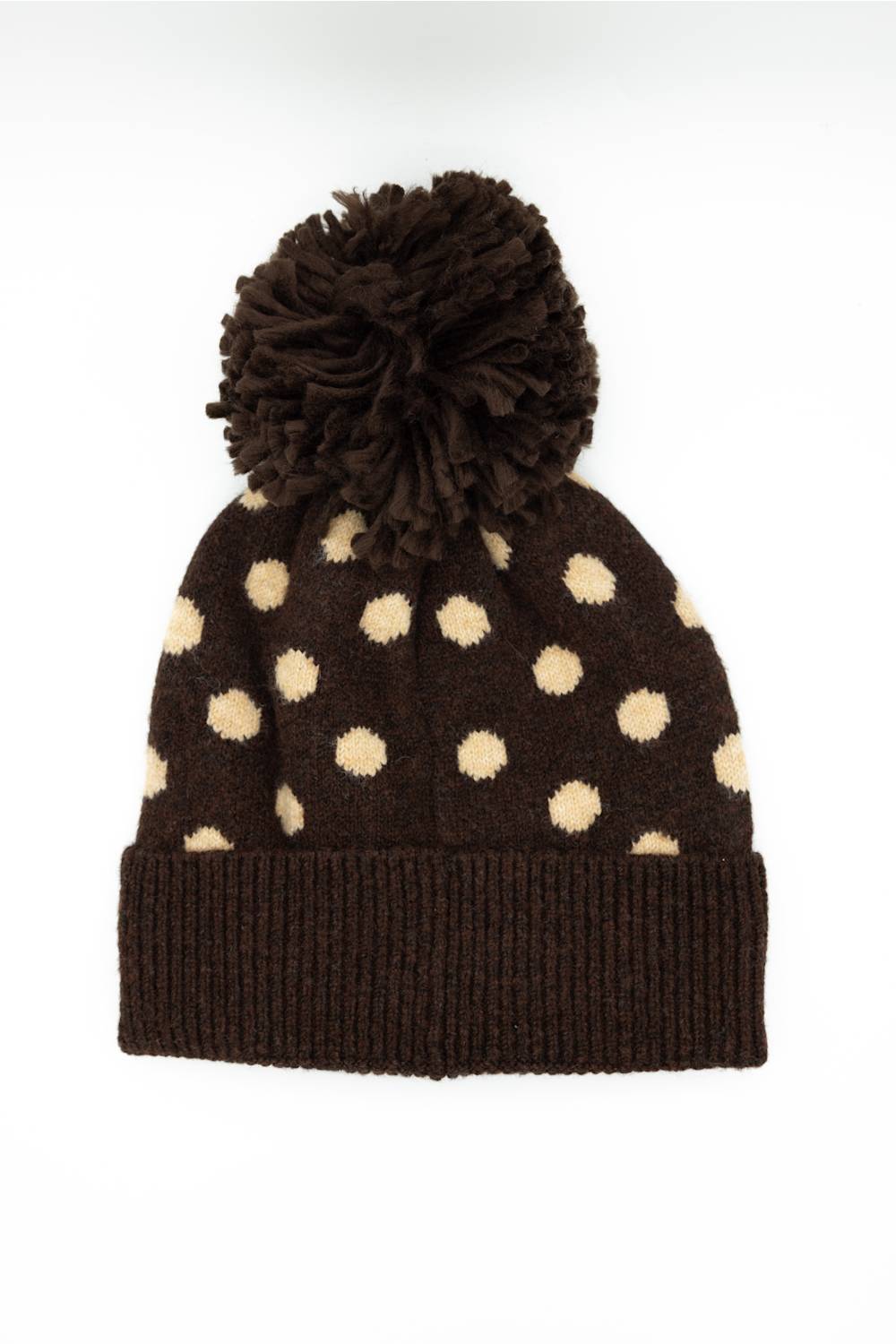 C.C. Polka Dot Pom Beanie for Women in Brown. Flat lay product photo of the back of the knit hat, showing the brown main color, cream polka dots, dark brown fuzzy pom-pom, and ribbed cuffed hem.