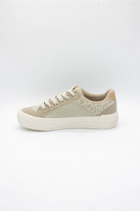 A low-top sneaker in beige and off-white, featuring a textured patterned side panel, beige laces, and a thick white platform sole, shown against a plain light gray background.