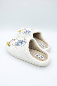 side view of dog wearing pajamas design on comfortable sherpa house slippers