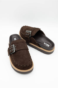A pair of dark brown suede slide sandals with braided trim and silver-tone buckle straps, displayed on a clean white background.