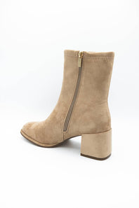 A beige suede ankle boot with a side zipper and a low block heel, shown from a three-quarter angle on a white background.