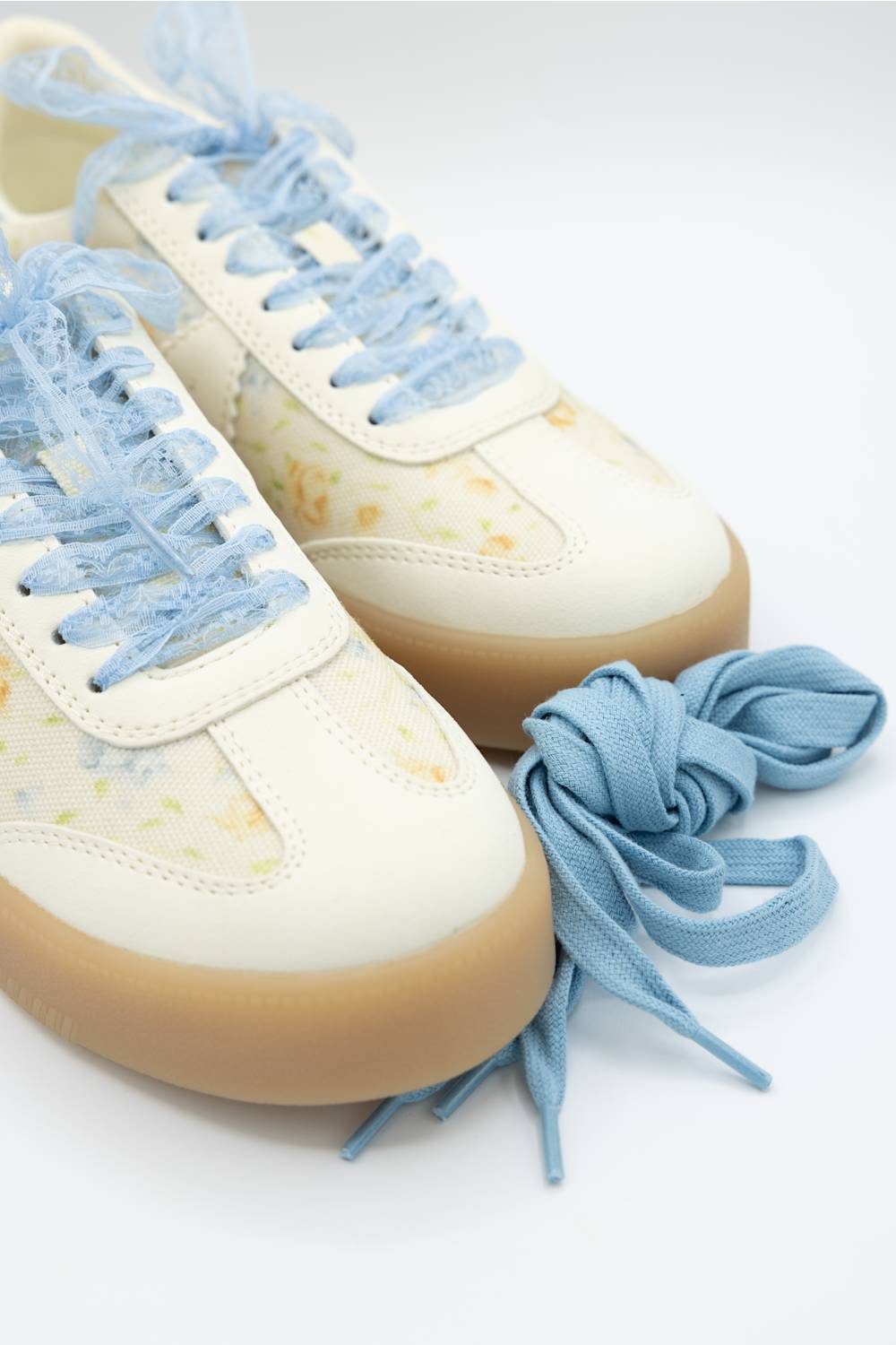 MIA Axel Sneakers for Women in Blue Floral; Pair of white sneakers with blue laces on a light background