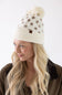 blonde woman modeling a cream and brown polka dot beanie 