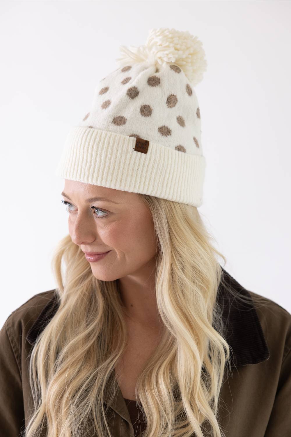 blonde woman modeling a cream and brown polka dot beanie 