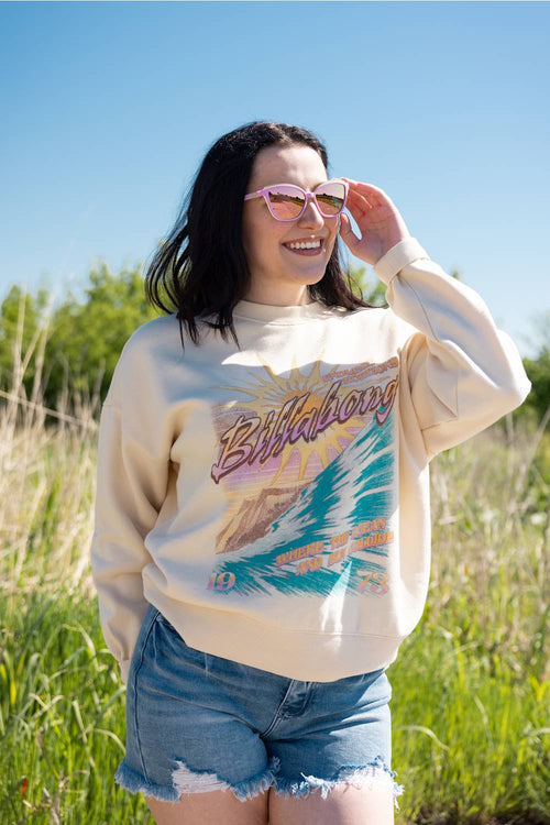 Woman wearing a vintage-style sweatshirt with a graphic design in a field