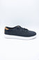 A low-top casual sneaker in dark navy blue with white soles and a light brown leather heel tab, displayed on a clean white studio background.