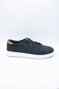 A low-top casual sneaker in dark navy blue with white soles and a light brown leather heel tab, displayed on a clean white studio background.