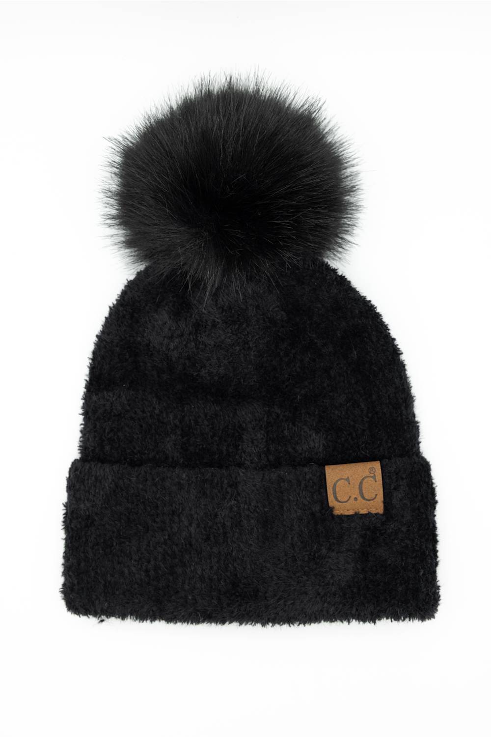 Front view of a black plush pom-pom beanie featuring a cuffed hem with a C.C. branded leather patch, set against a plain white background.