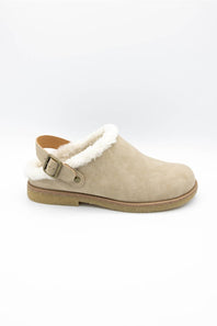 A single beige suede clog-style slipper with a white faux-shearling lining and a tan buckle strap, shown from the side on a white background.