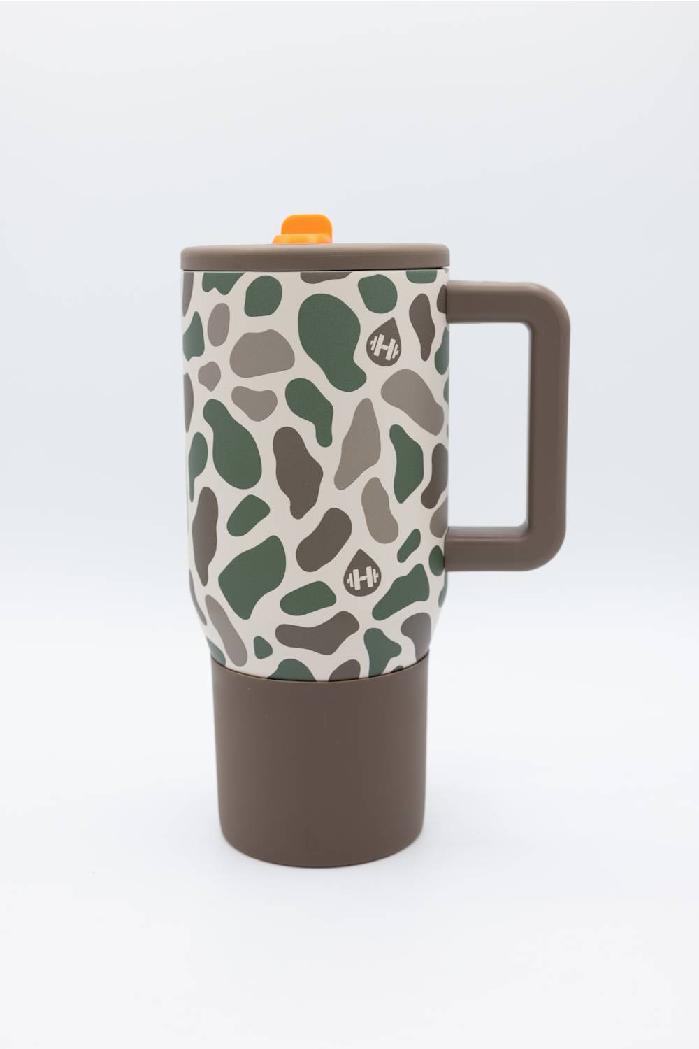A travel mug with a brown handle and base, featuring a beige upper body covered in an organic green and brown spot pattern, and topped with a brown lid and small orange accent.