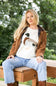 A woman wearing a cream-colored knit sweater with a detailed duck motif on the front