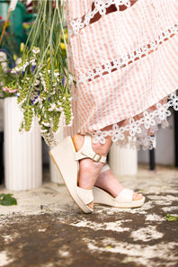 Soda Kate Wedges for Women in Off White; Person wearing white sandals with a pink dress and floral bouquet.