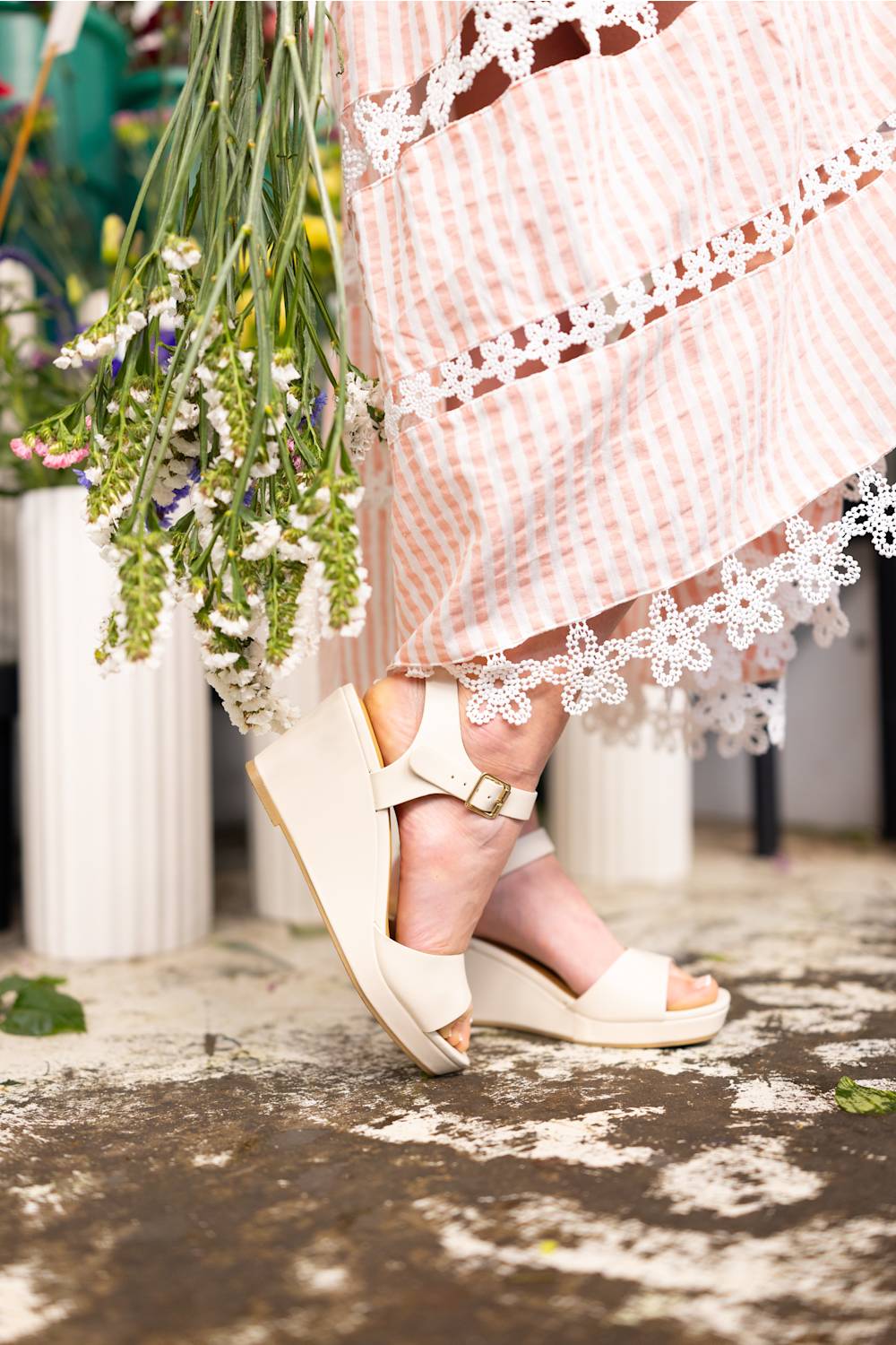 Soda Kate Wedges for Women in Off White; Person wearing white sandals with a pink dress and floral bouquet.