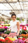 Urban Rib Flutter Sleeve Top for Women - White; Woman standing among colorful flowers in a greenhouse