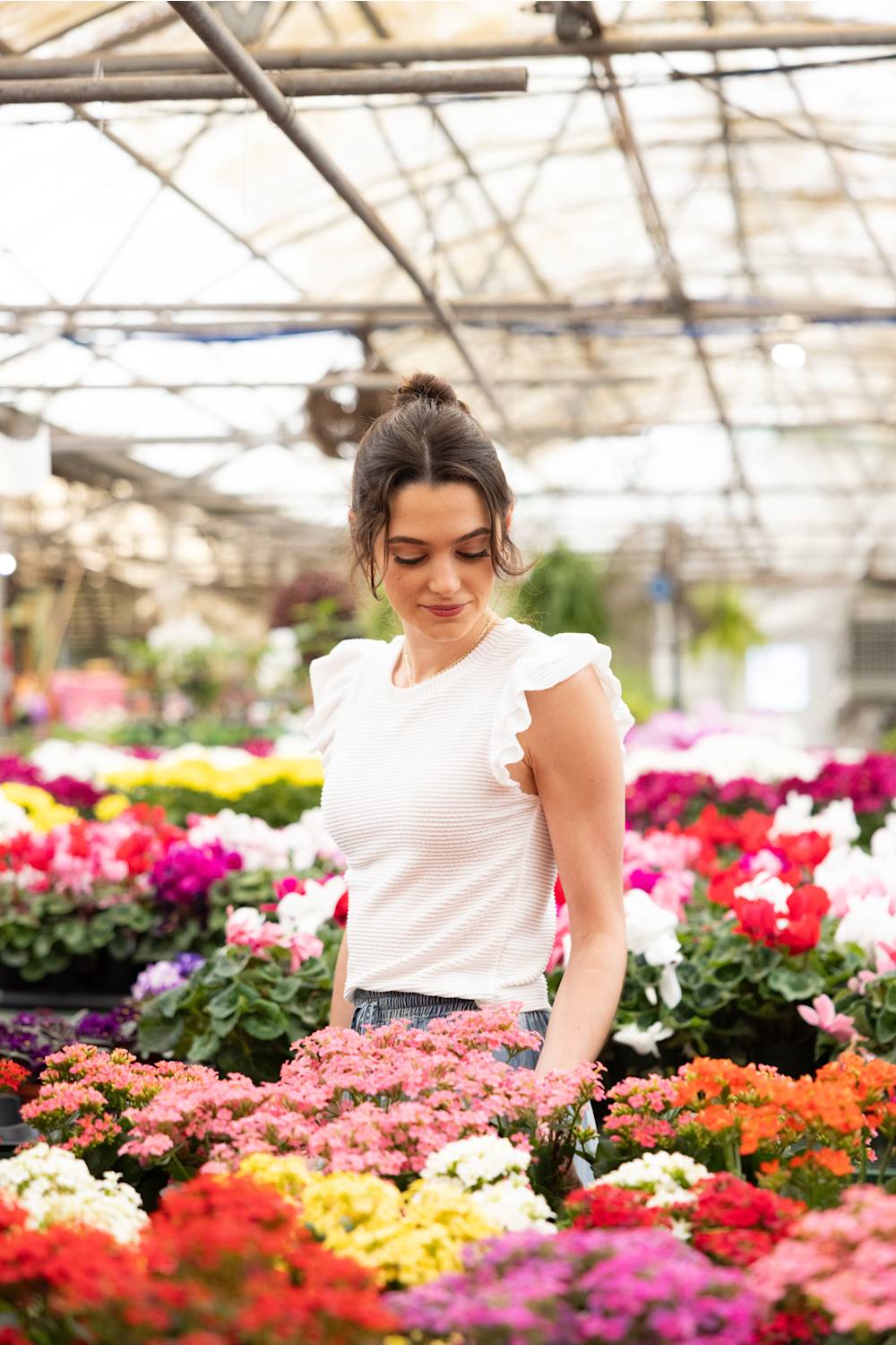 Urban Rib Flutter Sleeve Top for Women - White; Woman standing among colorful flowers in a greenhouse