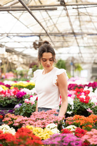 Urban Rib Flutter Sleeve Top for Women - White; Woman standing among colorful flowers in a greenhouse
