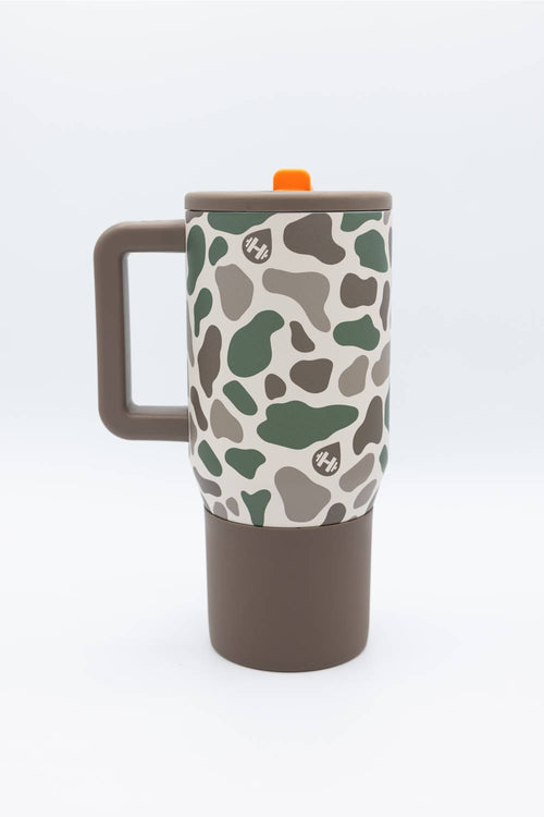A travel mug with a brown handle and base, featuring a beige upper body covered in a green and brown camouflage pattern. It has a matching brown lid with a small orange accent tab.