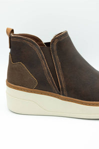 A dark brown leather ankle boot with elastic side panels and a chunky off-white platform sole, shown in a side profile view against a white background.