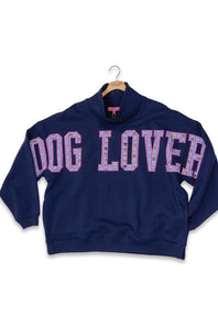 A navy blue mock-neck sweatshirt with 'DOG LOVER' printed across the chest in pink and purple patterned letters, hanging on a wooden hanger against a white background.