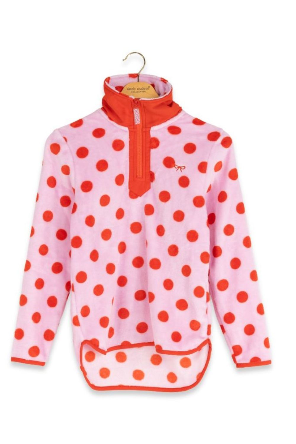 A pink fleece pullover jacket with red polka dots and a red half-zip collar, hanging on a wooden hanger against a white background.