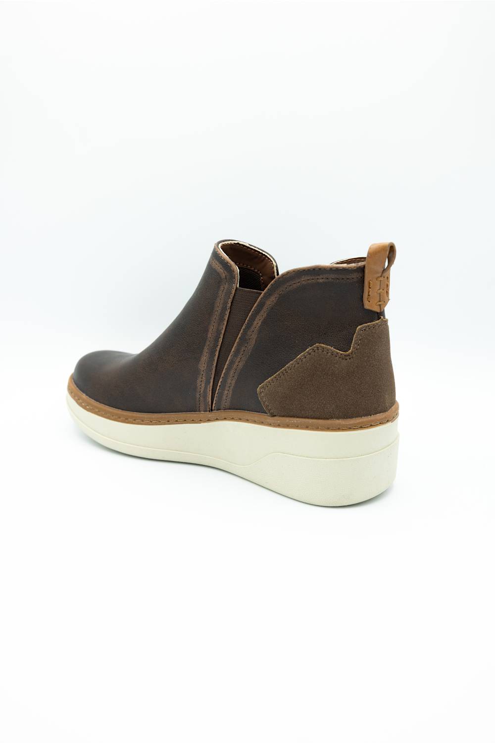 A dark brown leather and suede ankle boot with a thick cream-colored wedge sole, shown from a side-rear angle on a white background.