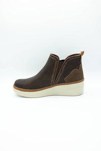 A dark brown leather ankle boot with a wedge heel and a light beige sole, shown from a side profile view on a white background.