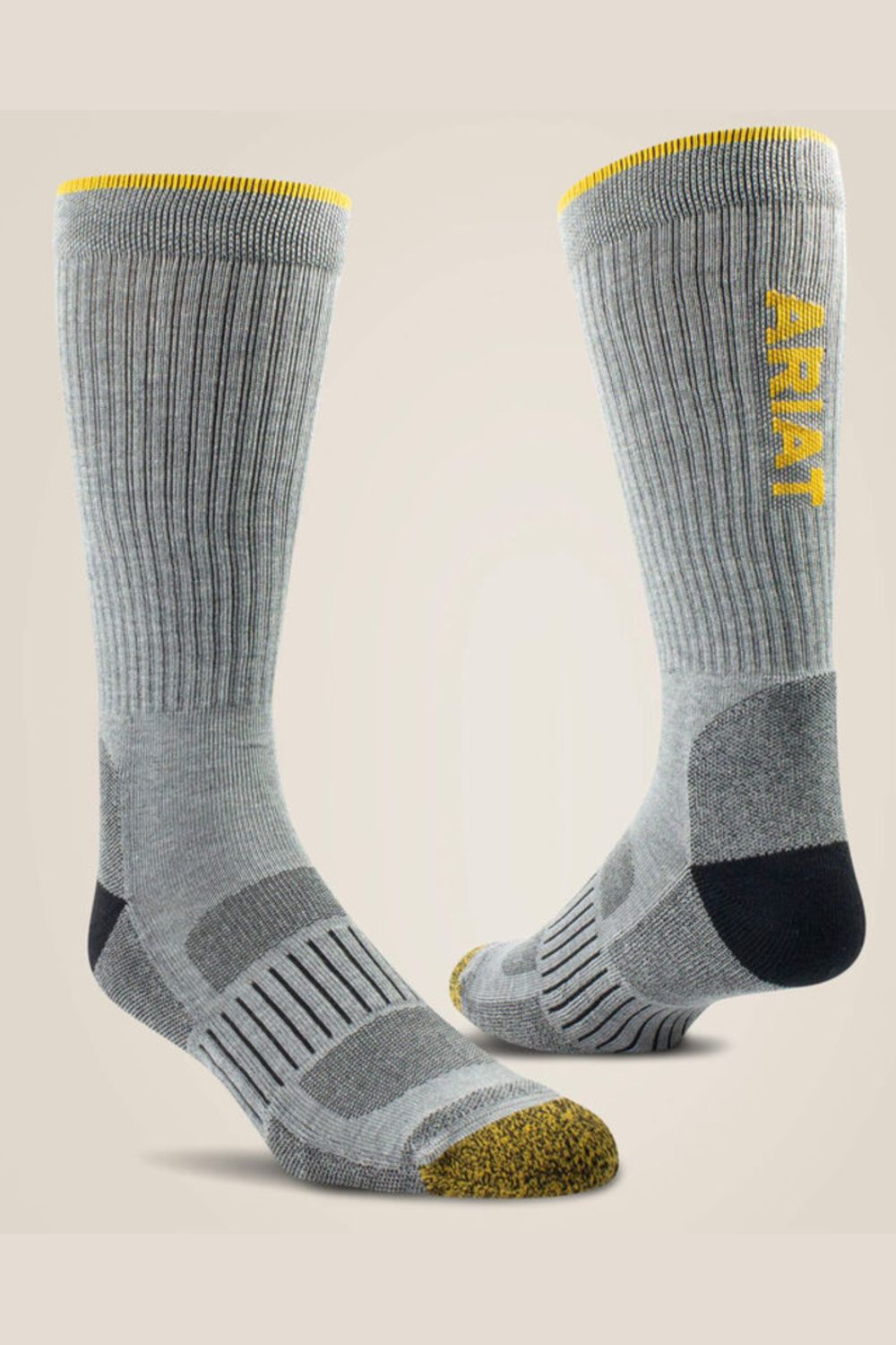 A pair of gray ribbed crew socks with yellow accents, including a yellow 'A-RIAT' logo on the side, a yellow toe cap, and a black heel, shown against a light beige background.