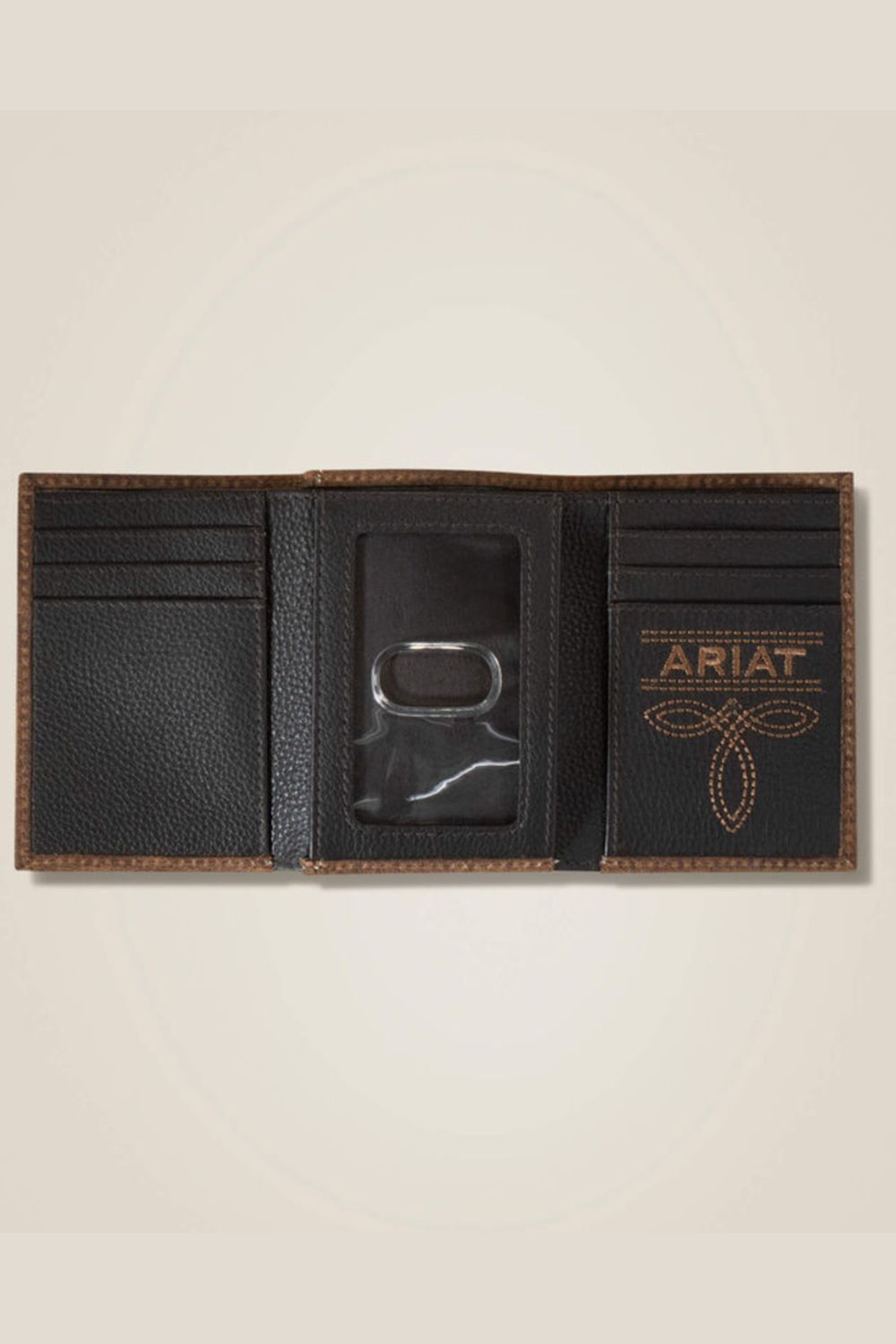 A black leather bifold wallet shown open, featuring card slots, a central ID window with a metal lock, and a tan embroidered ARIAT logo on the right panel, set against a light beige background.