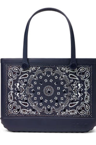 A navy blue tote bag featuring a large white paisley bandana print on the front panel and matching dark handles, shown against a plain white background.