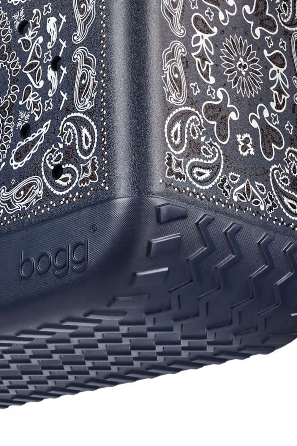 Close-up of a dark gray Bogg container with a white paisley bandana print on the sides and a textured dark gray base.