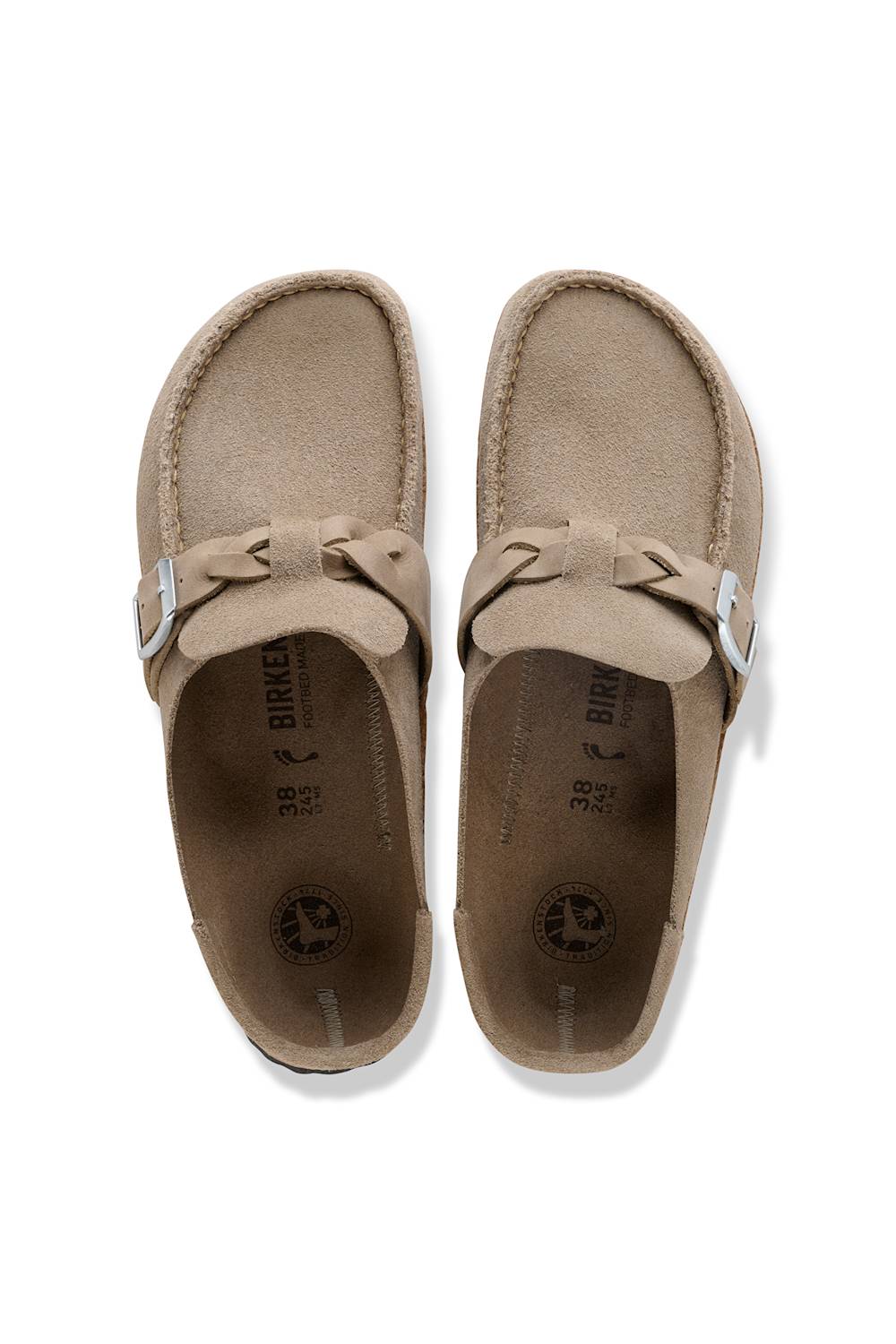 A pair of taupe suede moccasin-style shoes with bow details and silver buckle straps, shown from a top-down view on a white background.