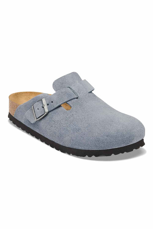 A single light blue suede clog shoe with a black sole and a silver buckle, shown from a three-quarters angle on a white background.