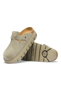 A pair of beige clogs with a strap closure and chunky soles, shown on a plain white background.