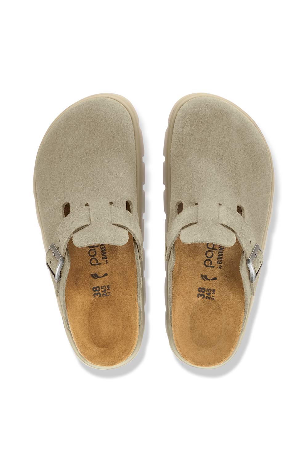 A pair of beige suede clogs shown from a top-down view on a white background. The shoes feature a wide strap with a small silver buckle and a tan insole with the brand name 'paco' visible.