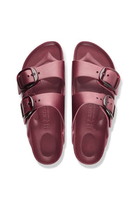 A pair of metallic rose gold double-strap slide sandals with silver-tone buckles, shown from a top-down view on a white background.