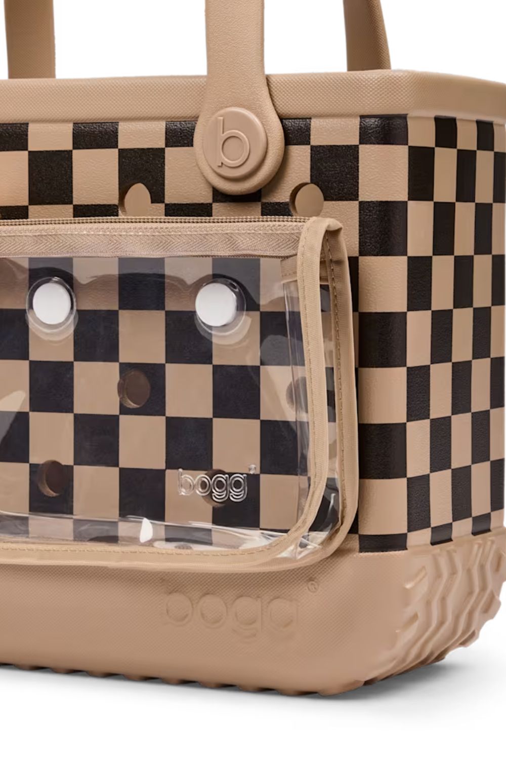 A close-up of a dog carrier bag with a beige and black checkerboard pattern, featuring a clear plastic front window and beige handles.
