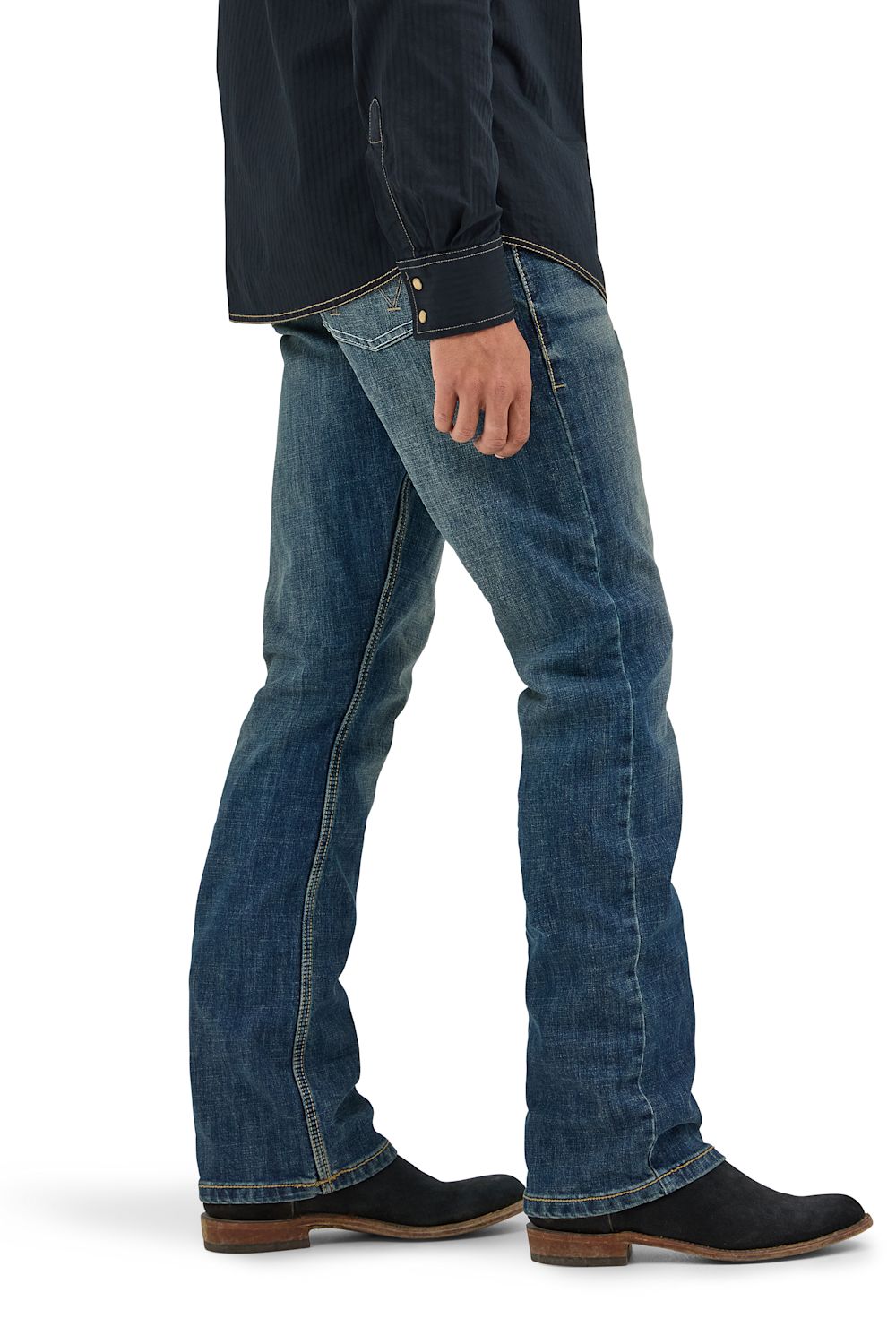 A person shown from the waist down wearing blue denim jeans, a dark navy jacket, and black boots against a plain white studio background.
