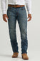 A person wearing medium-wash blue denim jeans with a brown belt and brown boots, shown from the waist down against a light gray studio background.